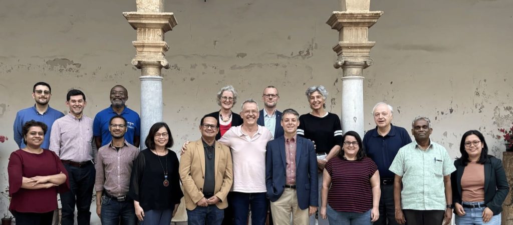 Members of the Concilium Board of Editors standing together in a cloister